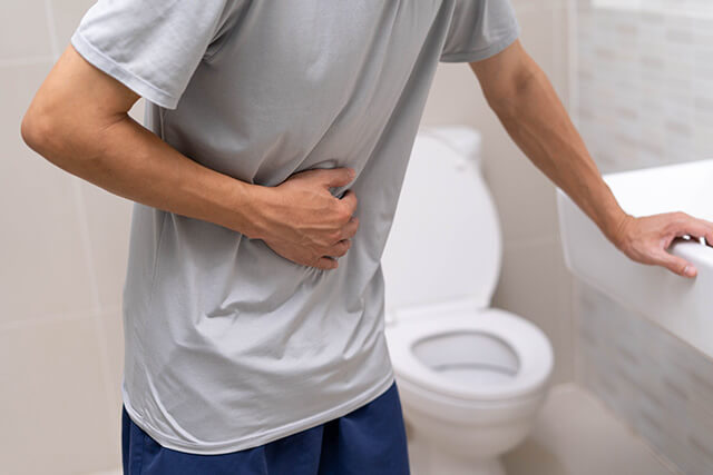 トイレで腹を押さえている男性