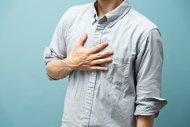 胸に手を当てている男性